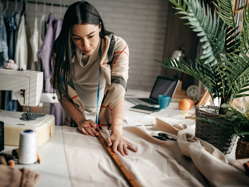 female textile worker cutting fabric seamstress