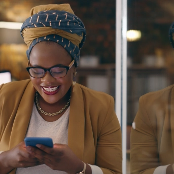 Ethinic woman in a head dress using a mobile phone