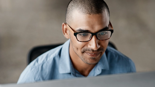 ethnic IT man studying his computer screen