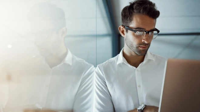 Young businessman working on his laptop in the office