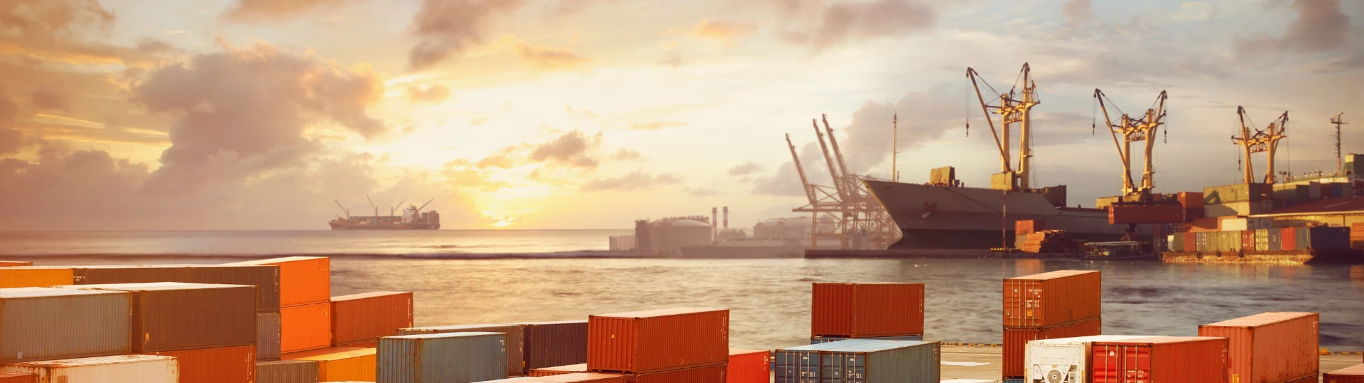 Shipping containers stacked up with sea in the background