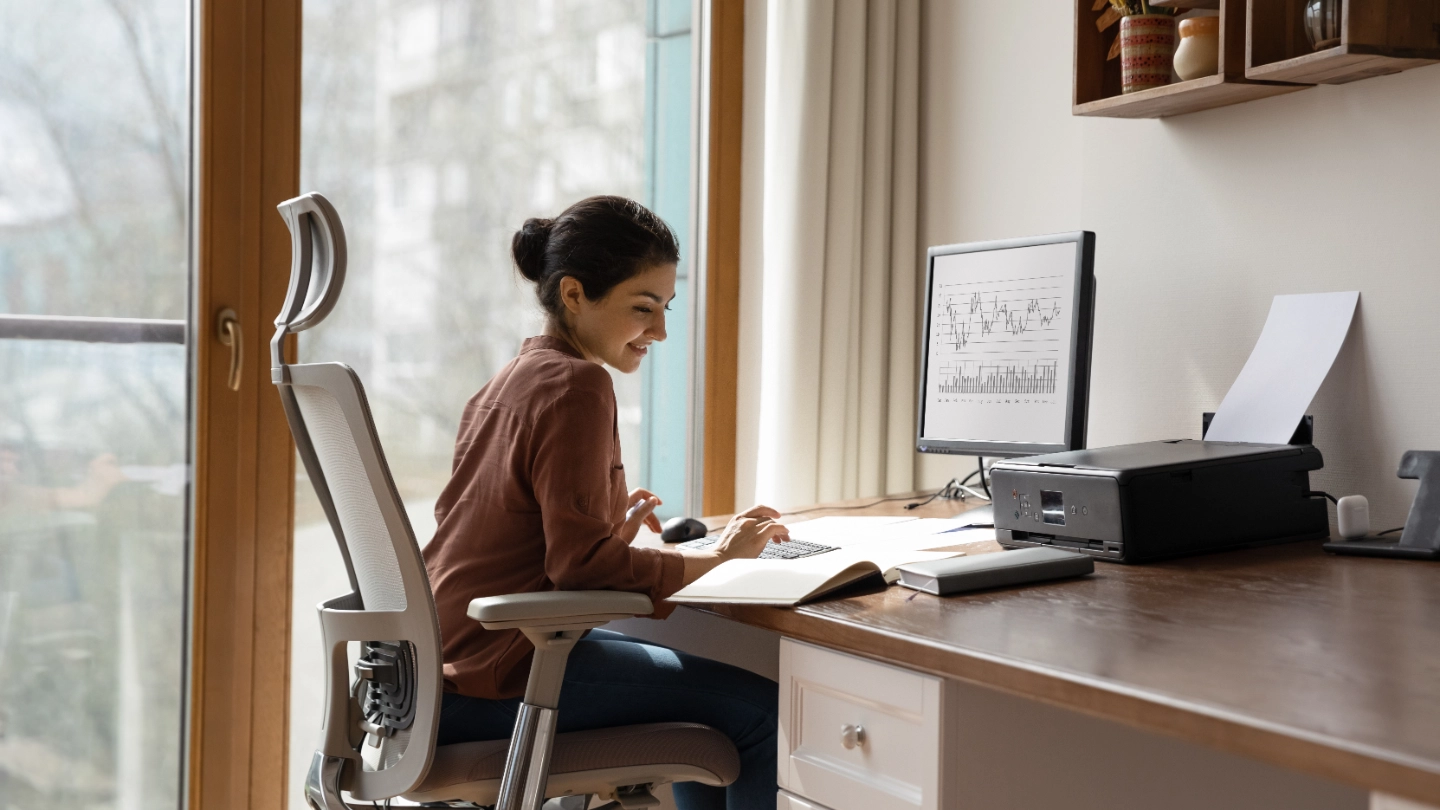 woman behind desk working on a computer woman behind desk working on a computer