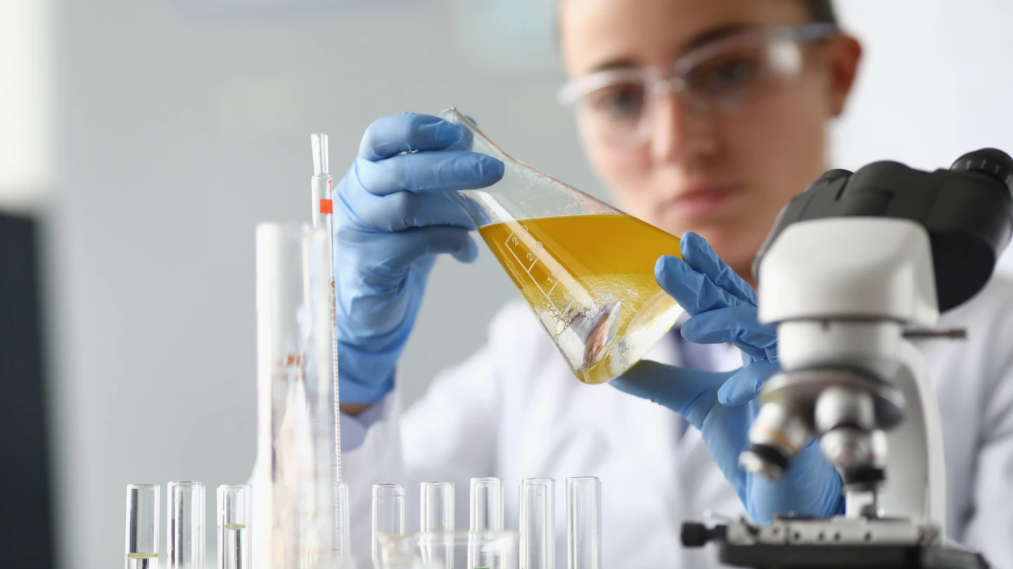 woman chemist scientist holding flask at hand