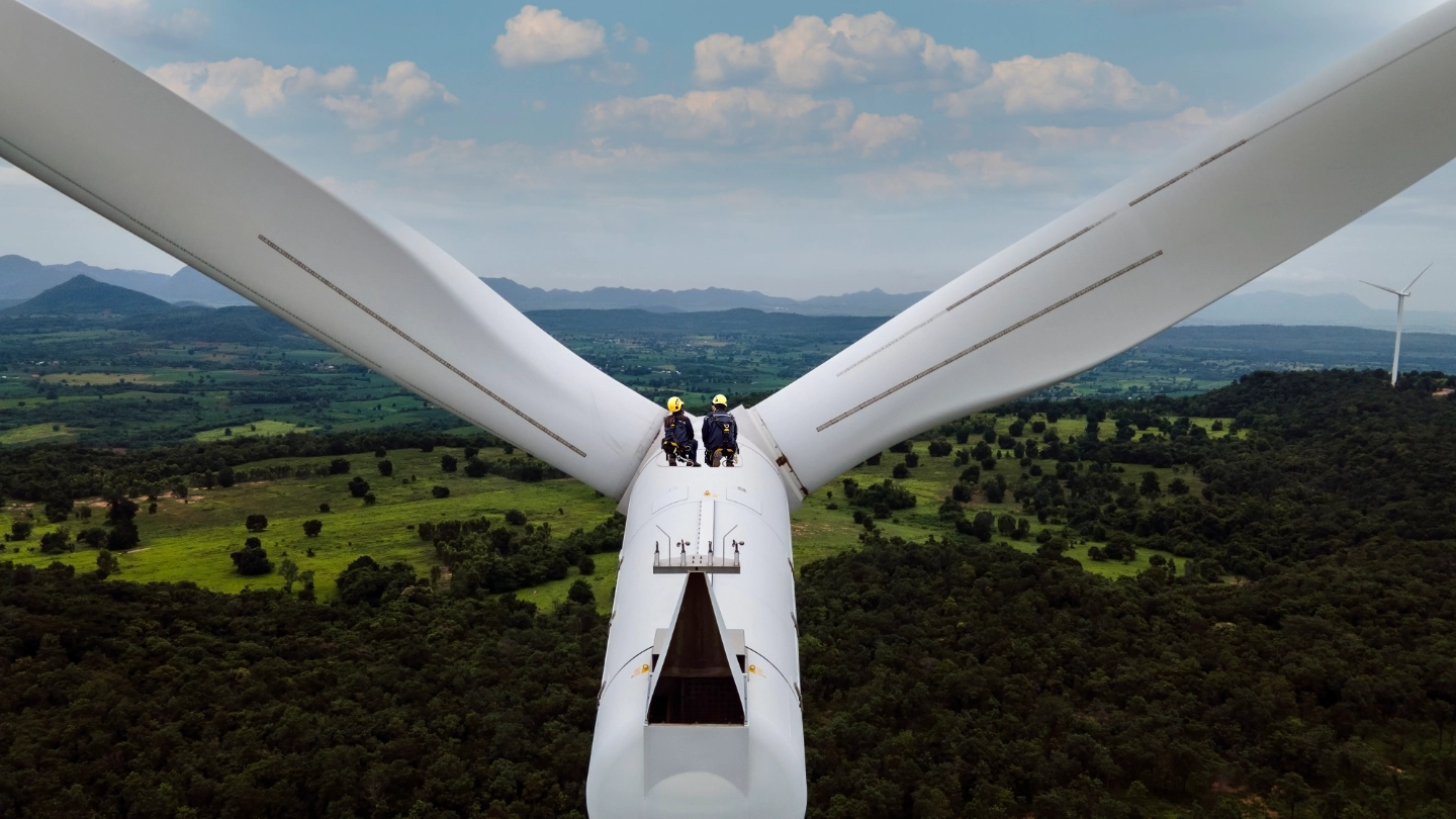 Two workers in the distance on a high level turbine
