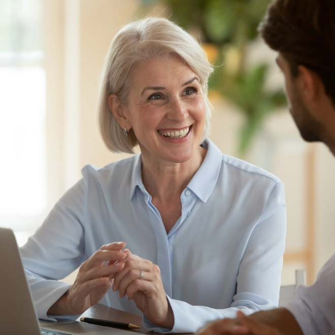 Middle aged woman talking to a male colleague