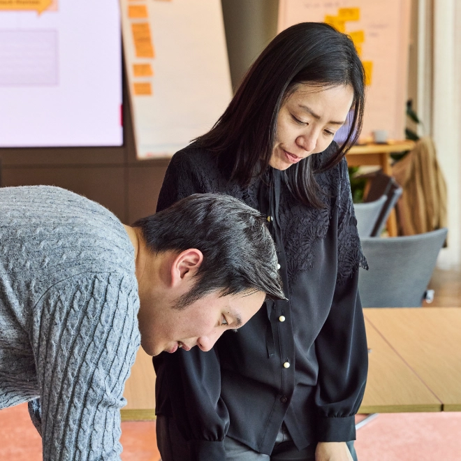 In workshop participating woman and man add their ideas on a sheet