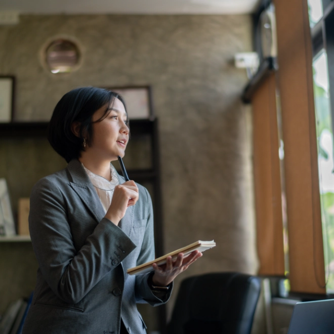 woman holding notebook and thinking